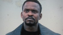 a close-up of a Black man looking concerned